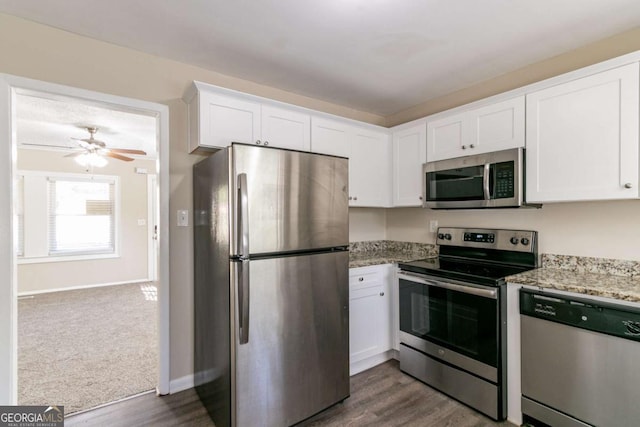 kitchen with light stone countertops, white cabinets, and stainless steel appliances