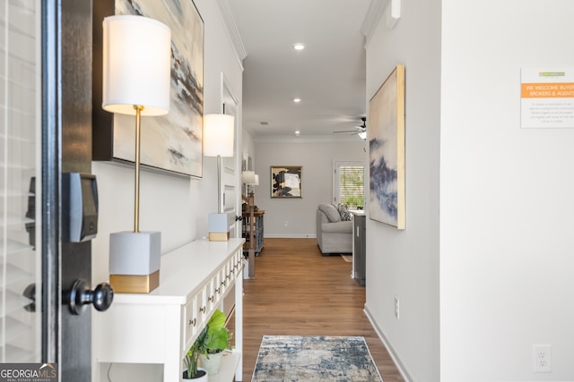 corridor with hardwood / wood-style flooring and crown molding