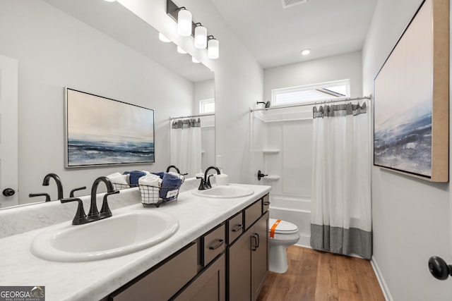 full bathroom with shower / bath combo with shower curtain, toilet, vanity, and hardwood / wood-style flooring