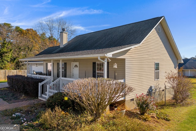 view of front of home featuring roof with shingles, a porch, crawl space, and a chimney