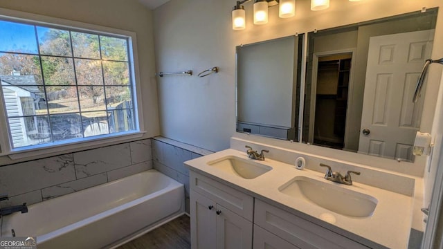 bathroom with hardwood / wood-style flooring, vanity, and a tub