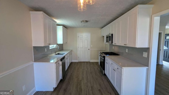 kitchen featuring white cabinetry, dark wood-type flooring, stainless steel appliances, and a textured ceiling