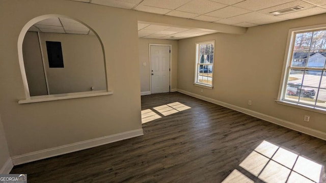 unfurnished room with a paneled ceiling, dark hardwood / wood-style flooring, and a wealth of natural light