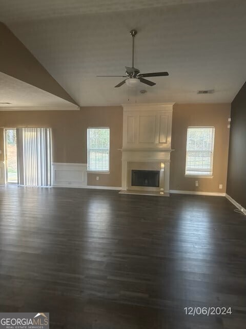 kitchen with ceiling fan, a fireplace, and dark wood-type flooring