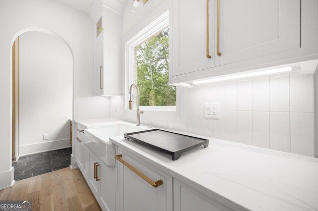 interior space with backsplash, hardwood / wood-style flooring, and sink