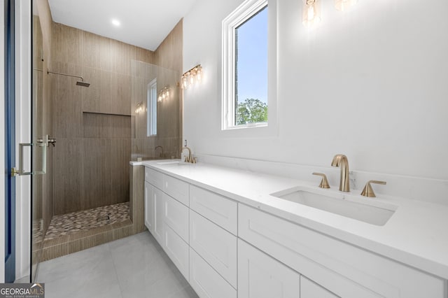 bathroom with tile patterned flooring, vanity, and tiled shower