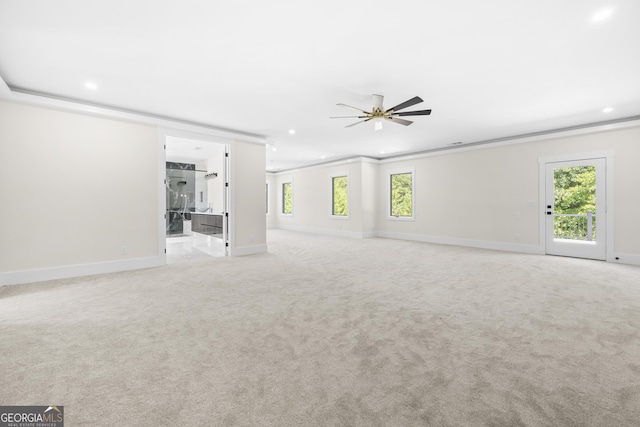 unfurnished living room with plenty of natural light, ceiling fan, and light colored carpet