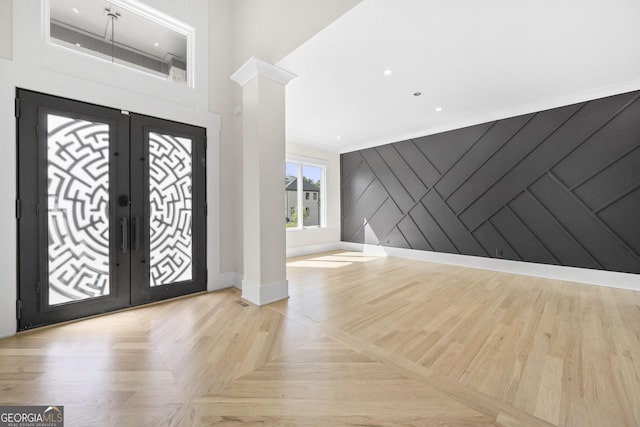 entryway featuring light parquet flooring, ornate columns, ornamental molding, and french doors