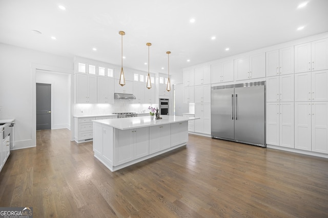 kitchen featuring white cabinets, dark hardwood / wood-style floors, hanging light fixtures, and appliances with stainless steel finishes