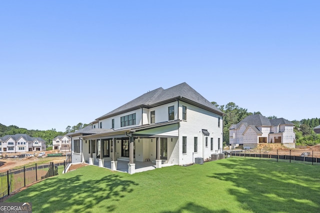 rear view of house featuring a lawn, cooling unit, and a patio