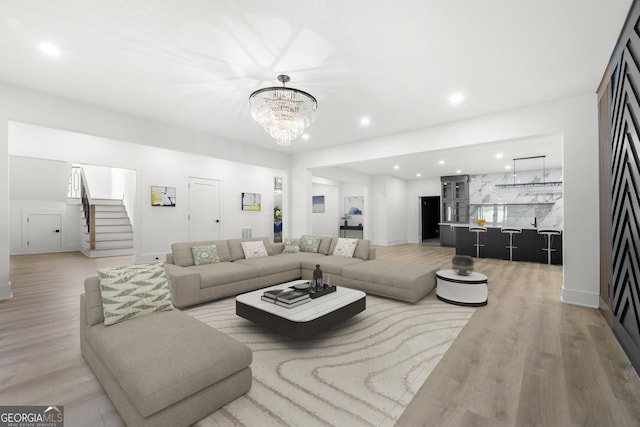 living room with light hardwood / wood-style floors and an inviting chandelier