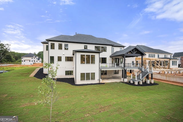 rear view of house with a patio, a deck, and a lawn