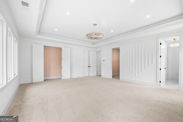 interior space with light carpet, connected bathroom, and a tray ceiling