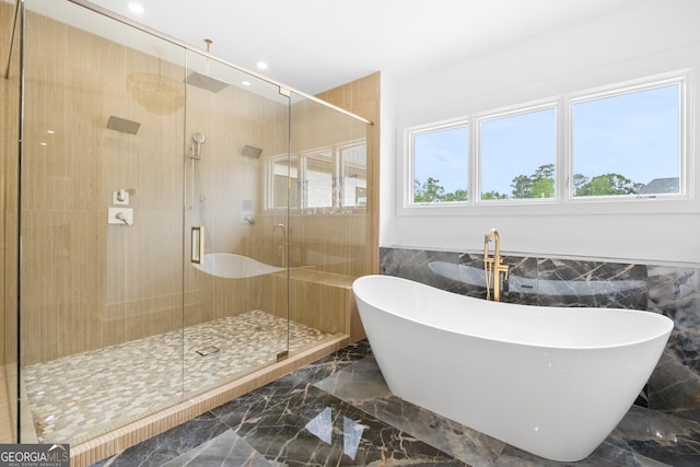 bathroom featuring tile walls and plus walk in shower