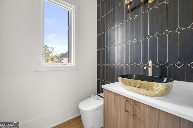 bathroom with hardwood / wood-style flooring, vanity, a healthy amount of sunlight, and toilet