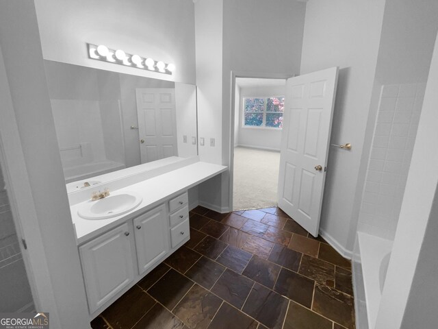 4279 Orchard Grv, Stone Mountain, GA 30083 - full bathroom featuring vanity, stone tile flooring, a tub to relax in, and a high ceiling