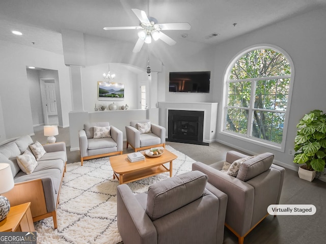 living room with ceiling fan with notable chandelier and lofted ceiling