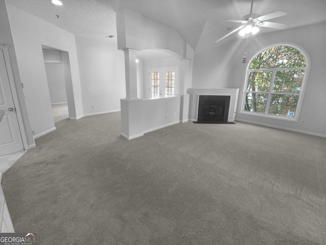 4279 Orchard Grv, Stone Mountain, GA 30083 - unfurnished living room featuring carpet, decorative columns, ceiling fan, a fireplace with flush hearth, and vaulted ceiling