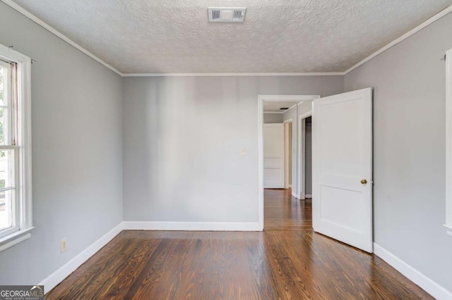 spare room featuring crown molding, dark hardwood / wood-style flooring, and a textured ceiling