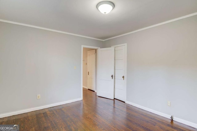 spare room with dark hardwood / wood-style floors and crown molding