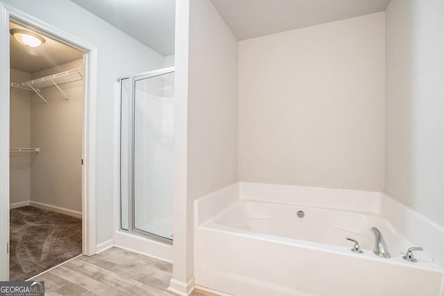 bathroom with wood-type flooring and separate shower and tub