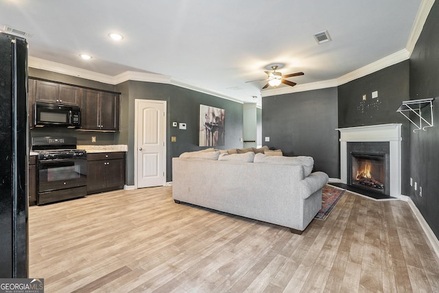 living room with ceiling fan, crown molding, and light hardwood / wood-style flooring