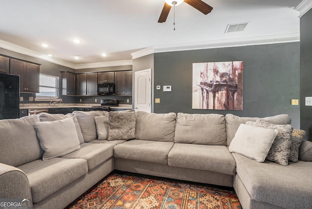 living room with ceiling fan, sink, and ornamental molding