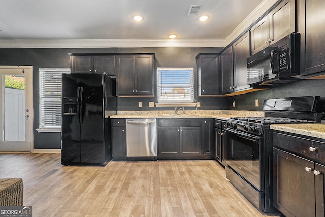 kitchen with black appliances, a healthy amount of sunlight, and light hardwood / wood-style floors