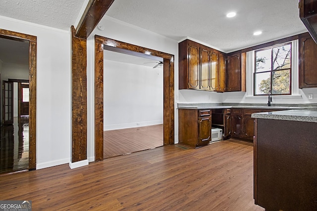 kitchen featuring dark hardwood / wood-style floors, ceiling fan, dark brown cabinets, and a textured ceiling