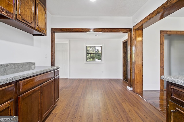 hall featuring dark hardwood / wood-style flooring, a textured ceiling, and ornamental molding