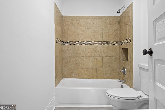 bathroom with toilet and tiled shower / bath