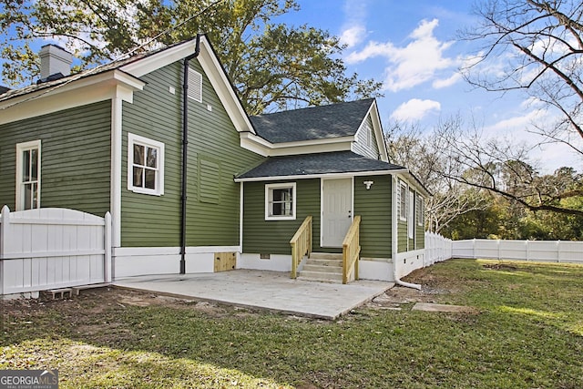 back of house with a lawn and a patio area