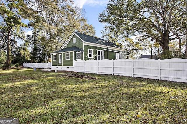 view of side of home with a yard