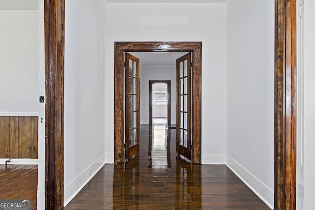 hallway with dark hardwood / wood-style flooring, ornamental molding, and french doors