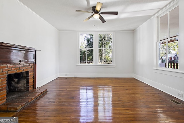 unfurnished living room featuring plenty of natural light, ceiling fan, dark hardwood / wood-style flooring, and crown molding