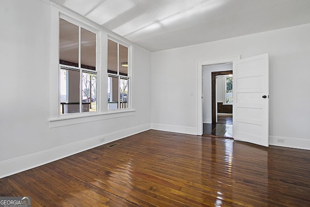 spare room with a textured ceiling, crown molding, and dark hardwood / wood-style floors