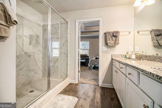 bathroom featuring hardwood / wood-style floors, vanity, and a shower with shower door