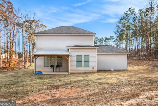 rear view of house featuring a lawn and a patio