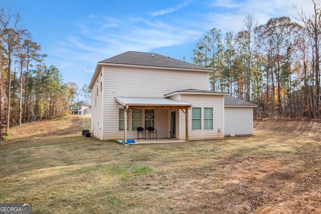 rear view of property featuring a lawn, a patio, and central AC