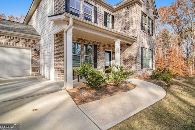 property entrance with covered porch and a garage