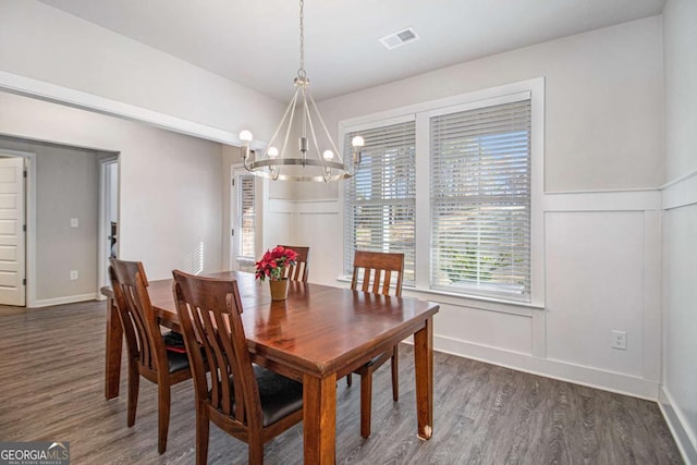 dining area featuring a notable chandelier and dark wood-type flooring