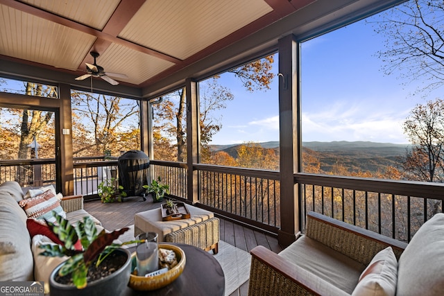 sunroom / solarium with a mountain view and ceiling fan