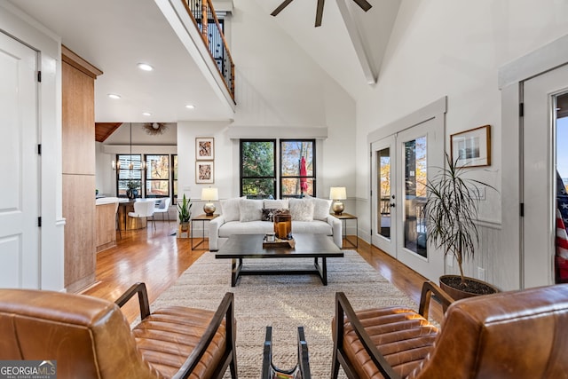 living room featuring ceiling fan, light hardwood / wood-style floors, high vaulted ceiling, and french doors