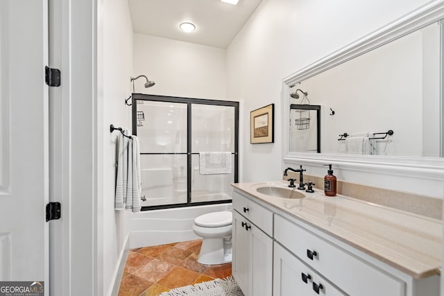 full bathroom featuring vanity, bath / shower combo with glass door, and toilet