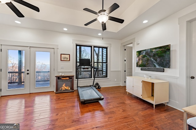 exercise room with ceiling fan, dark wood-type flooring, and french doors