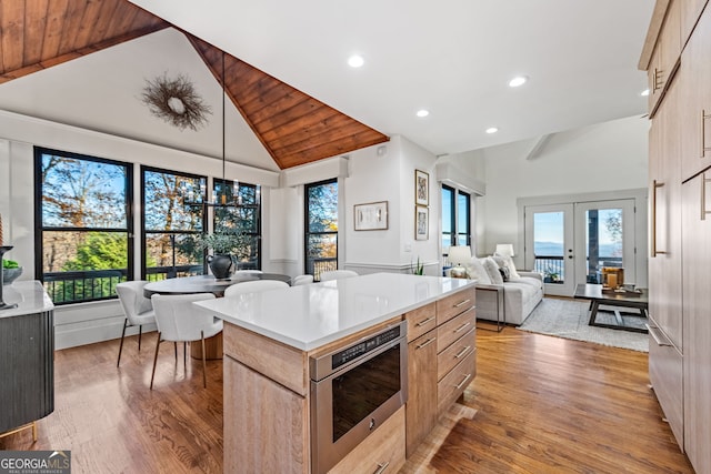 kitchen with light brown cabinetry, high vaulted ceiling, wood ceiling, and light wood-type flooring