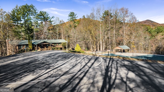 exterior space featuring a mountain view and basketball hoop