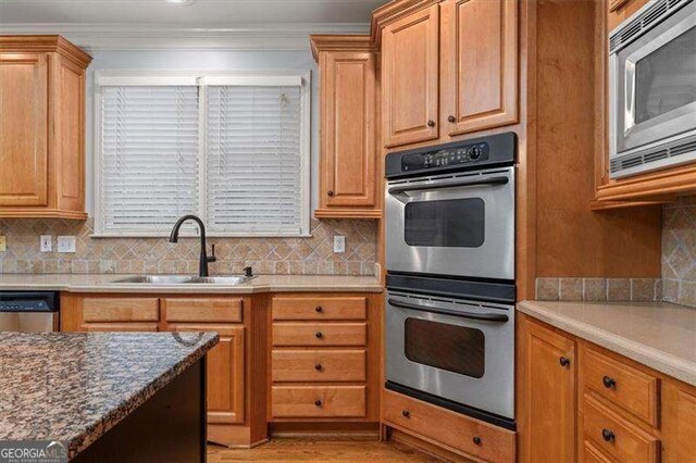 kitchen with tasteful backsplash, stainless steel appliances, light hardwood / wood-style floors, and sink