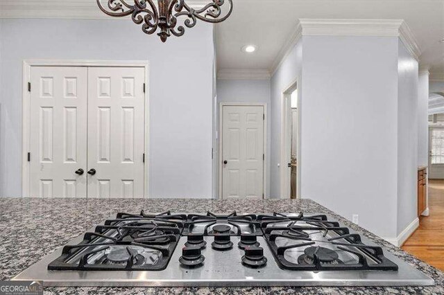 kitchen with sink, appliances with stainless steel finishes, tasteful backsplash, light stone counters, and ornamental molding