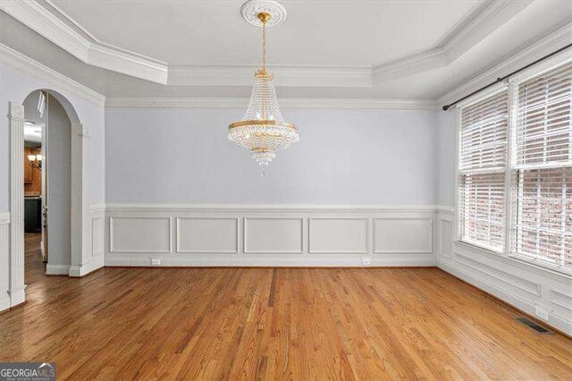 interior space with wood-type flooring, a healthy amount of sunlight, ceiling fan with notable chandelier, and ornamental molding